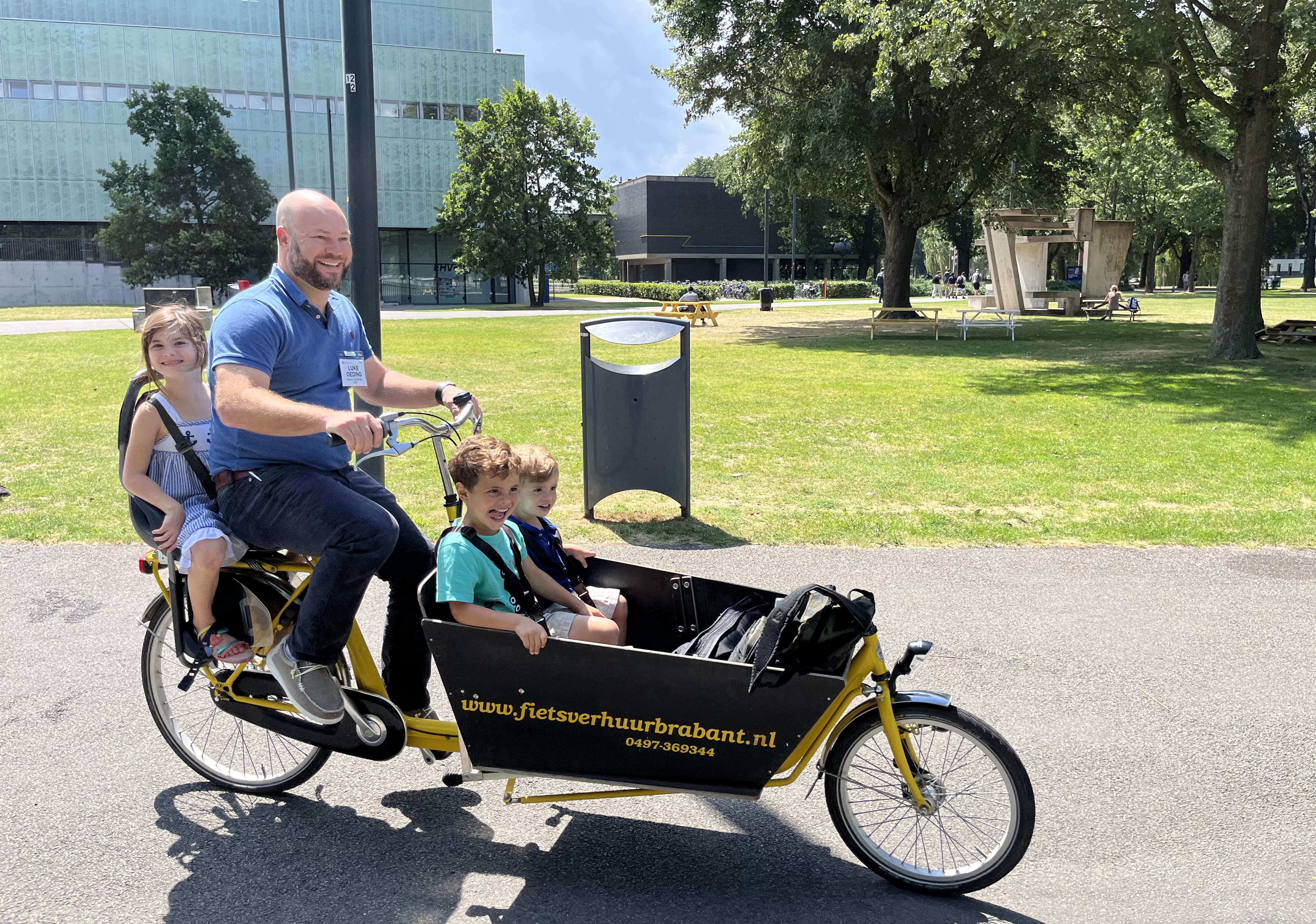 Luke Oeding and his children explore the campus of Eindhoven University of Technology in a cargo bike during a break from the technical sessions at the 2023 SIAM Conference on Applied Algebraic Geometry, which took place in July 2023. Image courtesy of Michael Burr.